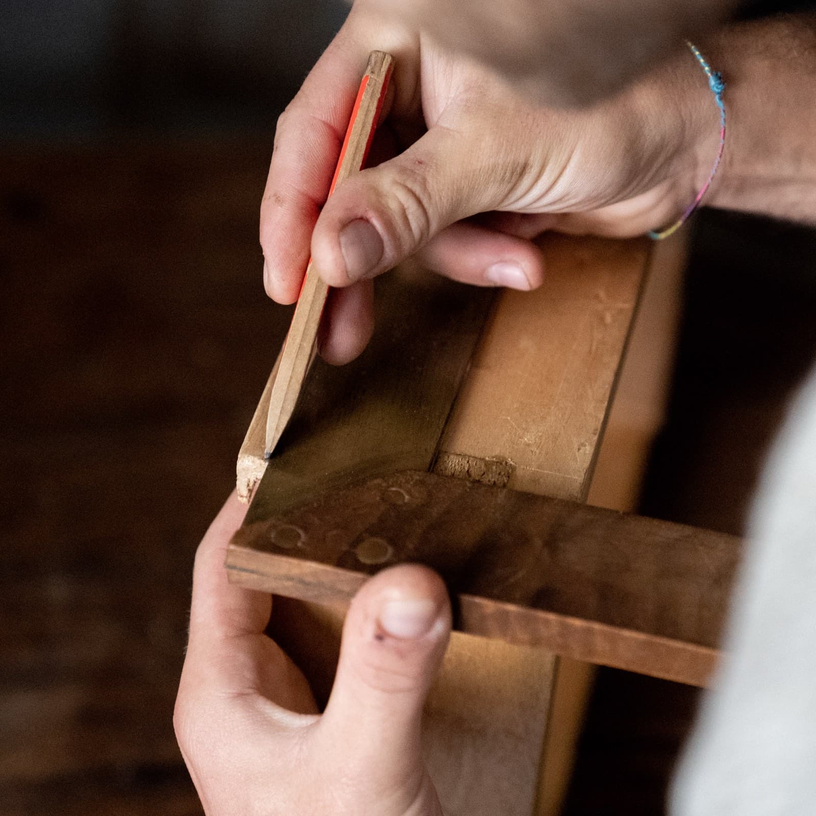 Artisan hands marking by pencil: the human craft behind every garment.